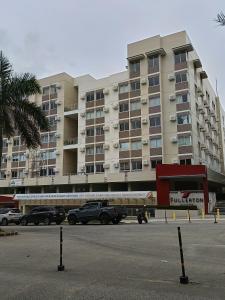 a large building with cars parked in a parking lot at Miranda's Suite by Fullerton in Silang