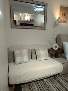 a white couch in a living room with a mirror at Miranda's Suite by Fullerton in Silang