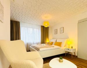 a bedroom with a large bed and a chair at Katy's Cozy Corner CityCenter in Graz