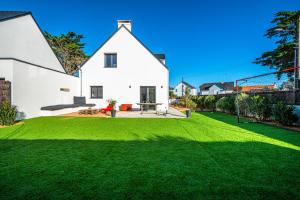 a white house with a yard with green grass at Ba-Batz Cool - Les Gîtes de la Côte d'Amour in Batz-sur-Mer