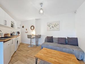 un soggiorno con un divano e un tavolo di Maison à 15 minutes de Disney, Paris et CDG 20mn. a Le Pin