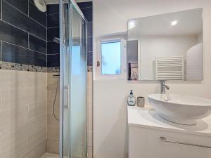 un bagno bianco con lavandino e doccia di Maison à 15 minutes de Disney, Paris et CDG 20mn. a Le Pin Altre 7 foto