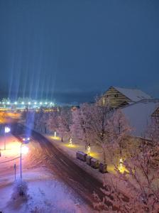 a snowy street with a train on it at night at Apartman Luka in Kupres