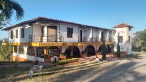 a house with a goat in front of it at Hotel Turístico El Cedral in Socorro
