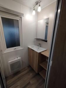 a bathroom with a sink and a window at Entre mer et montagne in Canet-en-Roussillon