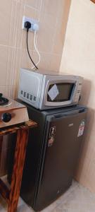 a microwave sitting on top of a refrigerator at Lakeview Suite in Naivasha +21 photos