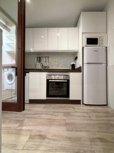a kitchen with white cabinets and stainless steel appliances at Apartamento PORTADA a 5 min andando de la playa con aire acondicionado in Estepona