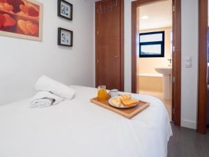 シエラネバダにあるMonte Oiz II-Fのベッドの上にオレンジジュースとパンが載ったトレイ