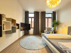 a living room with a bed and a tv at Feinzeit Lovely Lou - renovierter Altbau, Design, Zentrum! in Bamberg