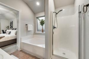 a white bathroom with a bath tub next to a bed at Luxury And Cozy Home 3BD, 2BATHS in Little Elm +28 photos