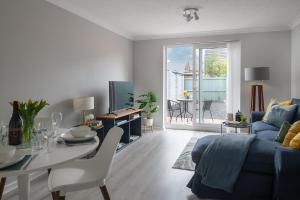 a living room with a blue couch and a table at Contemporary House Llanelli in Llanelli