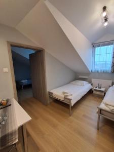 a attic room with a bed and a window at Villa Marcelina-Buk in Buk