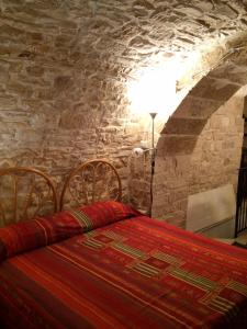 モルフェッタにあるCasa Vacanza Al Torrioneの石壁のベッドルーム1室(ベッド1台付)