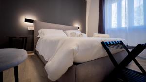 a bedroom with a large white bed and a window at Modern Room in Olbia