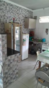 a kitchen with a refrigerator and a table in it at Casa no Guaibim in Valença