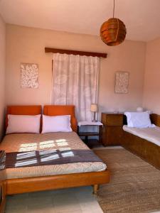 a bedroom with two beds and a window at THE COUNTRY HOUSE KOUTSOUPIA in Kókkinon Nerón