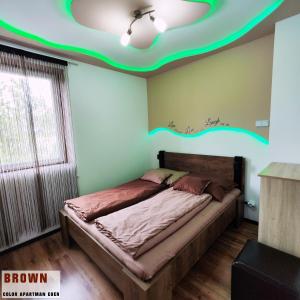 1 dormitorio con 1 cama con techo verde en Color Apartmanok Eger, en Eger