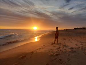 a man standing on the beach at sunset at casa sauce de portezuelo punta del este in Sauce de Portezuelo