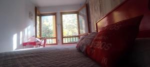 a bedroom with a coca cola bed and windows at Carlina Canfranc in Canfranc-Estación +22 photos
