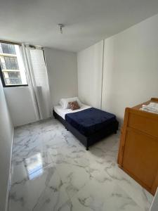 イバゲにあるapartamento 3 habitaciones con parqueaderoの大理石フロアのベッドルーム1室(ベッド1台付) +7枚の写真