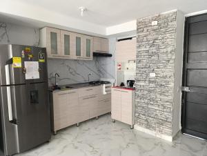 イバゲにあるapartamento 3 habitaciones con parqueaderoの石壁のキッチン(冷蔵庫付)