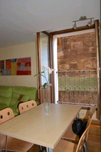 - un salon avec une table et des chaises dans l'établissement Cálido y acogedor apartamento en el corazón de Puente la Reina, à Puente la Reina