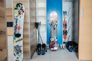 Een heleboel snowboards staan opgesteld tegen een muur. bij Golden Chalet in Boekovel