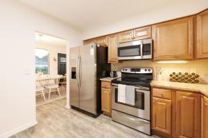 a kitchen with wooden cabinets and stainless steel appliances at Casa Bella Naples Vacation Home in Naples