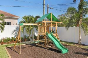 a playground with a slide in a yard at Casa Bella Naples Vacation Home in Naples