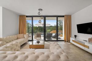 a living room with a couch and a tv at Santalezi Sunset Villa - Nature and Private Pool in Santalezi