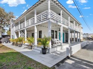 una casa bianca con palme di fronte di Ebb & Flow Apartment House a Tybee Island