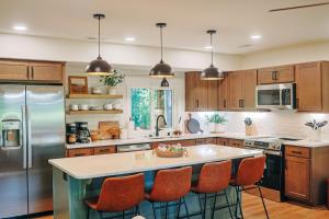 a kitchen with a large island with orange bar stools at Little River Retreat in Townsend