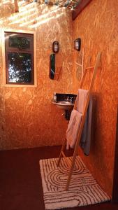 a bathroom with a sink and a chair in a room at The Urban Cabin in Knysna