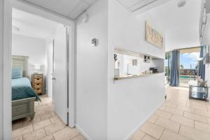 a bedroom with a bed and a door leading to a hallway at 1st Floor Resort Condo! No Elevators! Free Beach Chair Service! by Dolce Vita Getaways PCB in Panama City Beach