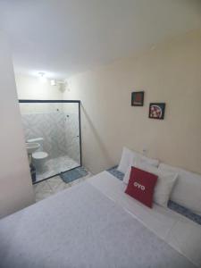 a bedroom with a bed with a red pillow on it at Pousada Deus Provera in Maceió +6 photos
