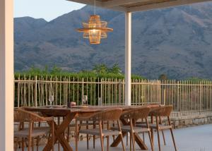 a wooden table with chairs and a chandelier at Pelagia's Loft Villas Haroupi & Rodi with Private Heated Pools, 5 Walking Distance to the Beach in Kavros