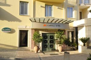 Castelli Hotel Nicosia في نيقوسيا: عماره فيها باب اخضر وعلامه فوقها