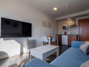 シエラネバダにあるMonte Oiz II-Eの青いソファとキッチンのあるリビングルーム +17枚の写真