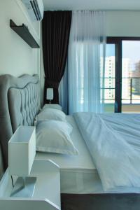 a bedroom with a large white bed and a window at Sea View Gallus Apartments in Caesar Resort & SPA, Long Beach in Perivolia tou Trikomou +21 photos