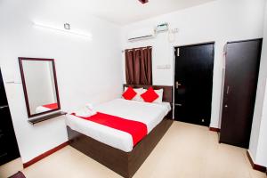 um quarto com uma cama com almofadas vermelhas e um espelho em Hotel 1Square em Pondicherry mais 2 fotografias
