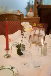 einen Tisch mit Brille und eine Vase mit Blumen in der Unterkunft Hotel Le Bellevue in Saint-Hippolyte