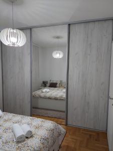a bedroom with a mirror with a bed in it at Stan na dan Banovic in Bijeljina