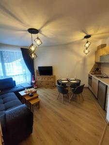 a living room with a blue couch and a table at Aspen Resort Studio I306 in Razlog
