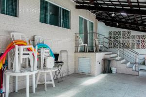 un gruppo di sedie bianche sedute accanto a un edificio di Praia do Frances - Casa Vista para o Mar - 50 metros da areia da praia a Praia do Frances Altre 12 foto
