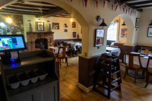a restaurant with a dining room with a fireplace at The Crown Aldbourne in Aldbourne