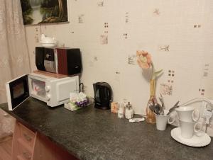a counter with a microwave on top of a counter at A comfortable room with balcony in Tallinn