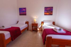 una habitación con dos camas y una mesa con lámpara en Liviko Beach Apartments - only adults, en Frangokastello