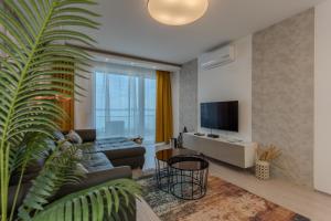 un soggiorno con un divano e una TV di GoldenHills Panorama Apartment a Fonyód