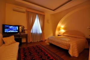a hotel room with a bed and a flat screen tv at Casale De Santis in Rome