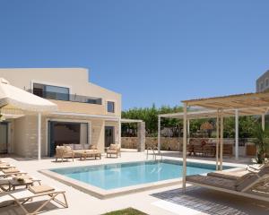 a villa with a swimming pool and a patio at Pelagia's Loft Villas Haroupi & Rodi with Private Heated Pools, 5 Walking Distance to the Beach in Kavros